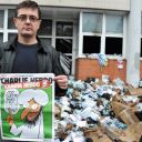 Charb montre la dernière Une de Charlie Hebdo devant les locaux du journal dévastés par un incendie criminel dans la nuit du 1er au 2 nnovembre 2011.