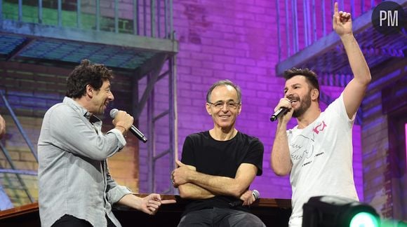 Michaël Youn, Jean-Jacques Goldman et Patrick Bruel lors d'un concert des "Restos du Coeur"